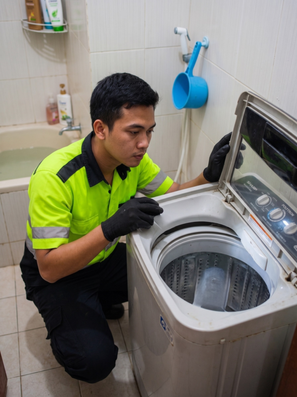 Tukang Service Mesin Cuci Sedang Mengecek Kondisi Mesin Cuci Satu Tabung